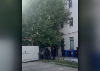 Femeie preluată de ambulanță cu ajutorul mascaților, după ce accesul în bloc a fost blocat cu lacăt