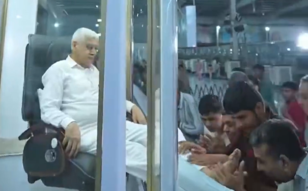 Lider spiritual din India: stă într-o cabină cu aer condiționat, iar adepții îi sărută picioarele